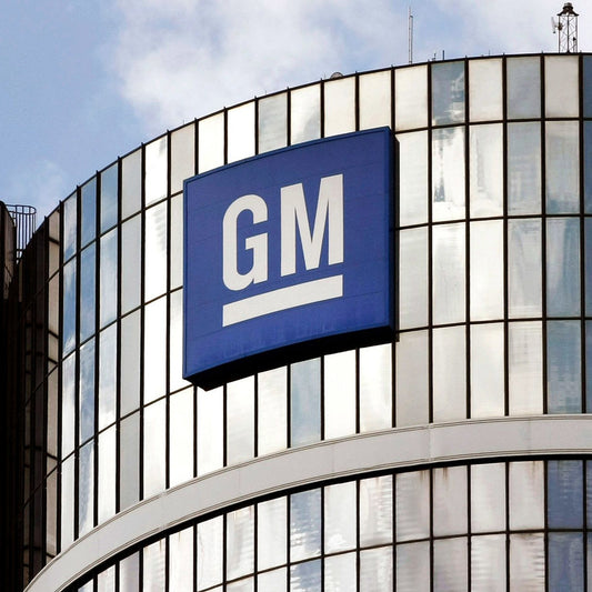 General Motors logo on a building facade with a blue sky background
